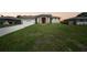 Charming single-story home with a well-manicured lawn, front-facing garage, and stone details at 1057 Presque Isle Dr, Port Charlotte, FL 33952
