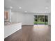 A living room with wood floors, an open-concept kitchen, and sliding glass doors to the outside at 1057 Presque Isle Dr, Port Charlotte, FL 33952