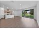 A living room with wood floors, an open-concept kitchen, and sliding glass doors to the outside at 1057 Presque Isle Dr, Port Charlotte, FL 33952