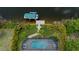 Aerial shot of the pool and backyard with lush landscaping and a private boat dock on the canal at 13471 Chenille Dr, Port Charlotte, FL 33981