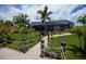 Lush backyard with a path to the private dock, surrounded by tropical plants and a screened-in pool at 13471 Chenille Dr, Port Charlotte, FL 33981