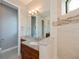 Bathroom featuring granite countertop, wood cabinets, large mirror and tiled shower at 13471 Chenille Dr, Port Charlotte, FL 33981