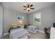 Bedroom featuring twin beds, natural light from window, a desk, and ceiling fan, creating a serene retreat at 13471 Chenille Dr, Port Charlotte, FL 33981