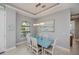 Inviting dining room with large window, modern light fixture, and a light blue dining table at 13471 Chenille Dr, Port Charlotte, FL 33981