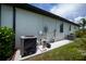 Side exterior featuring AC electrical box and some green bushes at 13471 Chenille Dr, Port Charlotte, FL 33981