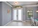 Light and airy foyer features a tiled floor, transom window, and double doors with frosted glass at 13471 Chenille Dr, Port Charlotte, FL 33981