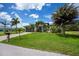 Charming single-Gathering home with a well-manicured lawn and a stylish driveway and several palm trees at 13471 Chenille Dr, Port Charlotte, FL 33981