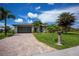 Well-maintained single-Gathering home with a lush green lawn, a brick driveway, and beautiful palm trees at 13471 Chenille Dr, Port Charlotte, FL 33981