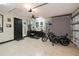 Organized garage featuring motorcycle, work station and sleek tool storage and tv with checkered accent wall at 13471 Chenille Dr, Port Charlotte, FL 33981