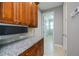 Kitchen pantry area with granite countertops, wood cabinetry, and microwave at 13471 Chenille Dr, Port Charlotte, FL 33981