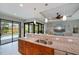 Gourmet kitchen featuring granite countertops and views of the pool and living area at 13471 Chenille Dr, Port Charlotte, FL 33981