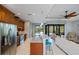 Bright kitchen featuring wooden cabinetry, stainless steel appliances, a breakfast bar and views into the open living area at 13471 Chenille Dr, Port Charlotte, FL 33981