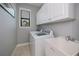 Functional laundry room boasts storage, modern appliances, and natural light from the window for added convenience at 13471 Chenille Dr, Port Charlotte, FL 33981