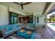 Inviting outdoor patio with stylish seating, ceiling fan, and easy access to the kitchen through sliding glass doors at 13471 Chenille Dr, Port Charlotte, FL 33981