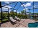 The screened-in pool area with lounge chairs provides views of the canal and boat dock at 13471 Chenille Dr, Port Charlotte, FL 33981