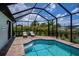 Relax in the refreshing screened pool with comfortable lounge chairs in this tropical backyard oasis at 13471 Chenille Dr, Port Charlotte, FL 33981