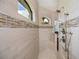 Luxurious walk-in shower boasting unique tile work, arched windows, and multiple shower heads at 13471 Chenille Dr, Port Charlotte, FL 33981