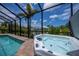 Inviting spa next to a beautiful screened pool with lush landscaping and privacy at 13471 Chenille Dr, Port Charlotte, FL 33981