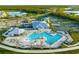 Aerial view featuring a resort-style pool, tennis courts, lake, and lush landscaping at community at 14141 Heritage Landing Blvd # 912, Punta Gorda, FL 33955