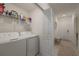 Efficient laundry room with washer, dryer, and shelving for storage with easy access to the front entry at 14141 Heritage Landing Blvd # 912, Punta Gorda, FL 33955