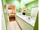 Bathroom featuring dual sinks, a large mirror, and access to the bedroom for convenience at 1431 Red Oak Ln, Port Charlotte, FL 33948
