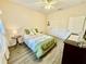 Bright bedroom with a ceiling fan, dresser, and a beautifully decorated bed with green accents at 1431 Red Oak Ln, Port Charlotte, FL 33948