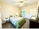 Bright bedroom with a ceiling fan, dresser, and a beautifully decorated bed with green accents at 1431 Red Oak Ln, Port Charlotte, FL 33948