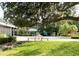 Beautiful courtyard featuring a charming seating area, mature trees, and lush landscaping at 1431 Red Oak Ln, Port Charlotte, FL 33948