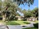 Charming single-story home featuring lush landscaping, mature trees, and a circular driveway at 1431 Red Oak Ln, Port Charlotte, FL 33948
