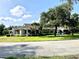 Beautiful single-story home surrounded by mature trees, lush lawn, and well-manicured landscaping at 1431 Red Oak Ln, Port Charlotte, FL 33948