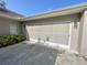 The property has an oversized garage door, painted in neutral colors with exterior lighting at 1431 Red Oak Ln, Port Charlotte, FL 33948