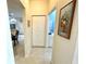 Hallway view leading to a bathroom and other living areas, featuring neutral tile flooring at 1431 Red Oak Ln, Port Charlotte, FL 33948