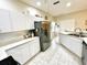 Bright kitchen featuring tile flooring, stainless steel refrigerator, and white cabinets at 1431 Red Oak Ln, Port Charlotte, FL 33948