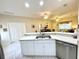 A kitchen with white cabinets and a view to the dining and living areas at 1431 Red Oak Ln, Port Charlotte, FL 33948