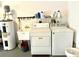 Functional laundry room features a washer, dryer, utility sink, and overhead shelving at 1431 Red Oak Ln, Port Charlotte, FL 33948