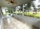 Screened-in porch has ceramic tile floor, ceiling fan and a beautiful view of manicured lawns at 1431 Red Oak Ln, Port Charlotte, FL 33948