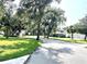 Scenic neighborhood street lined with lush trees, green lawns, and well-maintained homes at 1431 Red Oak Ln, Port Charlotte, FL 33948