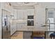 Modern kitchen with stainless steel appliances, granite countertops, and ample cabinet space at 15039 Black Cherry Way, Punta Gorda, FL 33955