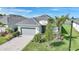 Beautiful exterior view of the home, featuring a gray roof, a driveway, and landscaping at 15039 Black Cherry Way, Punta Gorda, FL 33955