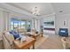 Comfortable living room with large windows offering lake views and a modern fireplace at 15039 Black Cherry Way, Punta Gorda, FL 33955