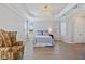 Bright bedroom with stylish chandelier, tray ceiling, and an accent chair at 15039 Black Cherry Way, Punta Gorda, FL 33955