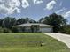 Single story home with a manicured lawn, a gray roof, and a two car garage in a suburban setting at 1609 Log Ln, North Port, FL 34286