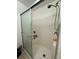 Clean and functional shower area with white tile walls, a sliding glass door, and built-in shelving at 1609 Log Ln, North Port, FL 34286