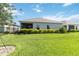 Green backyard with a line of manicured bushes at 16824 Canopy Garden Dr, Port Charlotte, FL 33953