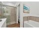 Bright bathroom featuring a glass enclosed shower, separate tub, and wood-look tile at 16824 Canopy Garden Dr, Port Charlotte, FL 33953