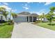 Charming single-story home showcases a two-car garage, paver driveway, and meticulously manicured lawn at 16824 Canopy Garden Dr, Port Charlotte, FL 33953