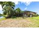 Lush backyard with mature landscaping, partial canal view, and a fenced area for privacy and relaxation at 17150 Sarong Ln, Punta Gorda, FL 33955