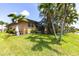 Lush backyard featuring mature palm trees, green lawn, and views of the canal, providing a private retreat at 17150 Sarong Ln, Punta Gorda, FL 33955
