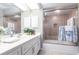Bathroom featuring a dual sink vanity, framed mirror and tiled shower-tub combination at 17150 Sarong Ln, Punta Gorda, FL 33955