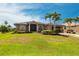 Well-maintained home with lush landscaping, mature palm trees, and a welcoming curb appeal in a desirable neighborhood at 17150 Sarong Ln, Punta Gorda, FL 33955